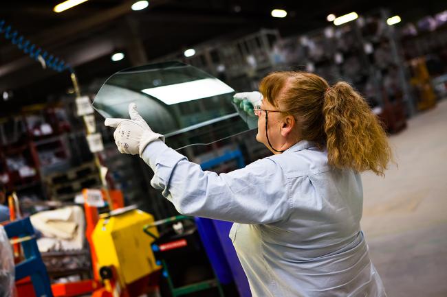 1 woman works with protective gloves in a factory